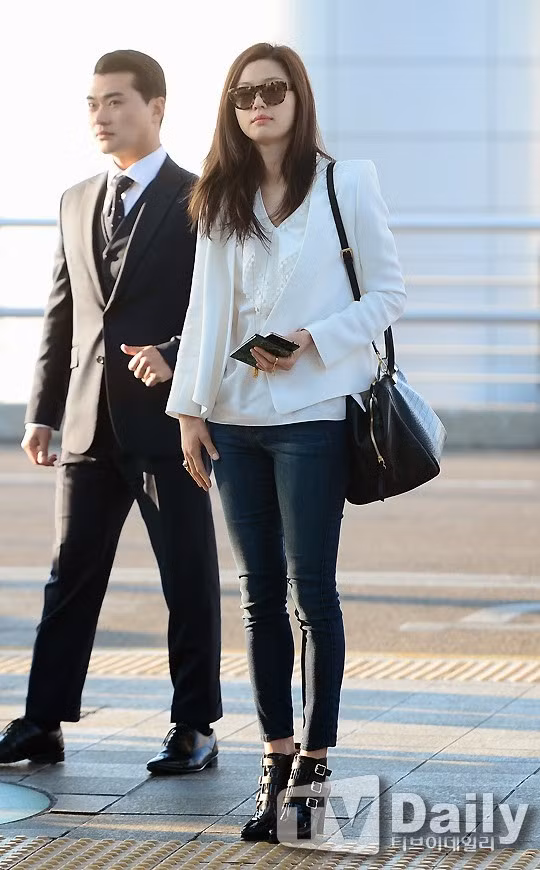 Gu thời trang đường phố của Jung Ji Hyun năng động với quần legging đen kết hợp áo phông, vest không cổ tone trắng và đôi boot cao gót.