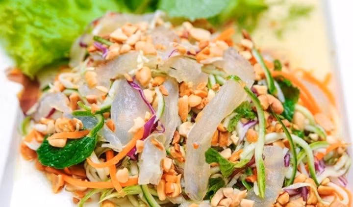 Gỏi cá đục thường ăn kèm với rau sống các loại như lá đinh lăng, lá sung, húng quế, rau mùi… và không thể thiếu bánh tráng nướng giòn rụm. Ảnh dulichluhanh