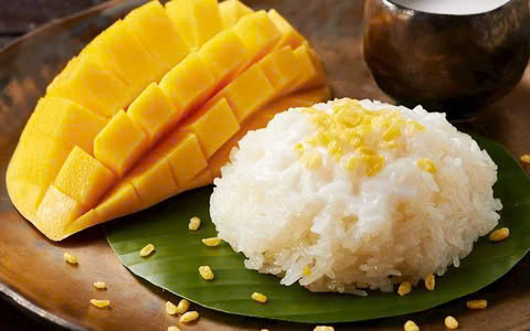 Mùa hè ở Thái Lan không chỉ được biết đến với cái nóng oi ả mà còn là thời điểm lý tưởng để thưởng thức một món tráng miệng nổi tiếng: xôi xoài (mango sticky rice). Đây là món ăn dân dã nhưng lại được yêu thích nồng nhiệt, không chỉ bởi hương vị tuyệt vời mà còn vì sự kết hợp tinh tế giữa các nguyên liệu tự nhiên. Ảnh MIA
