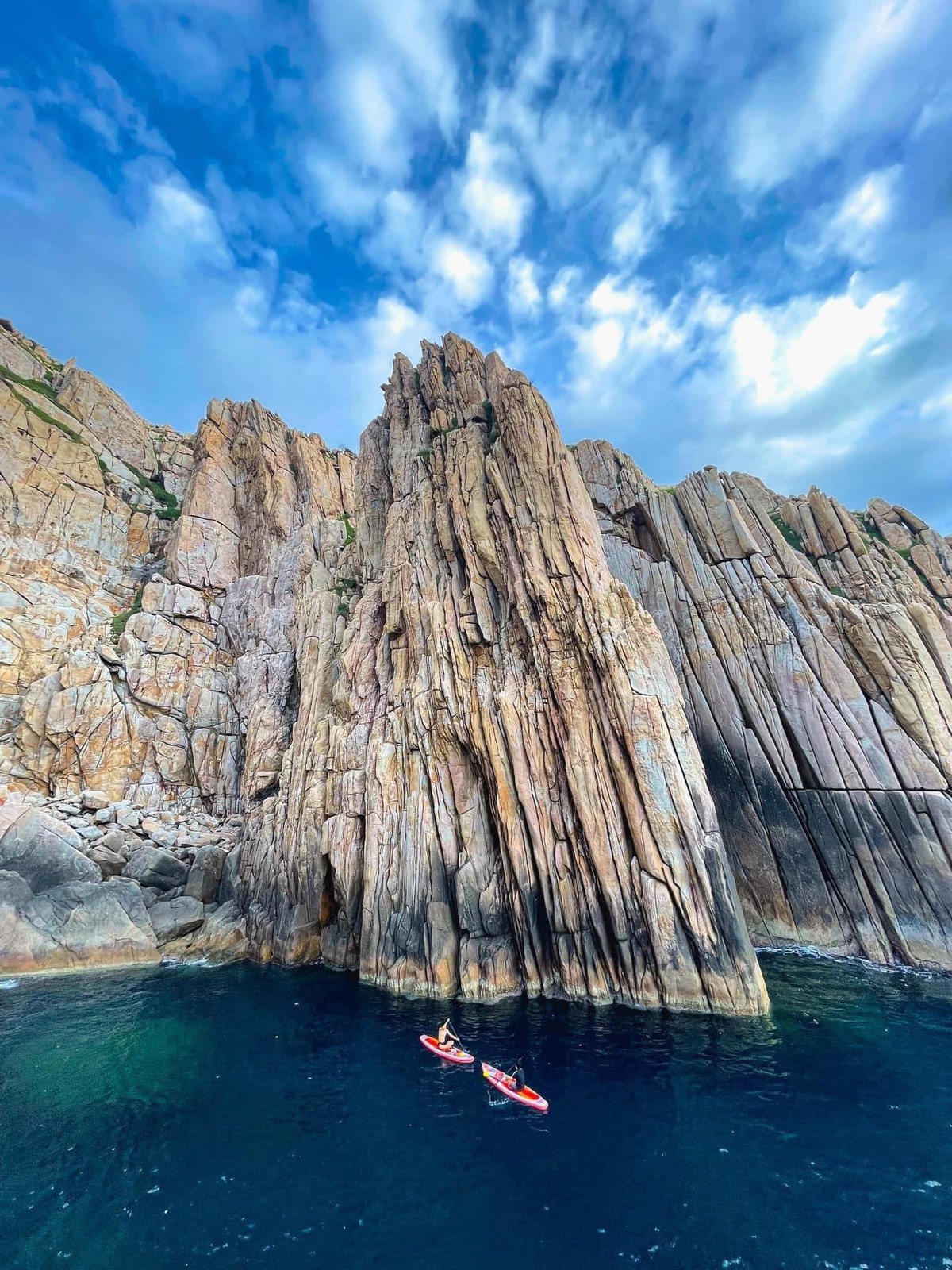 Với những khối đá to lớn, sắc nét và những vách đá cheo leo, Bãi Đá Vách là một trong những điểm đến không thể bỏ qua đối với những ai yêu thích khám phá vẻ đẹp hoang sơ của thiên nhiên. Mặt biển Vĩnh Hy trong xanh, sóng vỗ nhẹ vào bờ, tạo nên âm thanh du dương, như một bản nhạc tự nhiên hòa quyện với những dãy đá vững chãi. Ảnh dulichvietnam