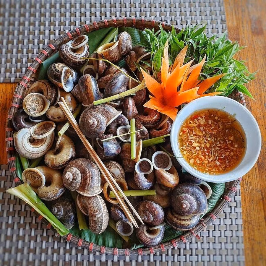 Ốc xu là loại ốc sống trong các khe đá trên núi Bà Đen, chỉ xuất hiện vào mùa mưa. Với thịt ngọt và giòn đặc trưng, ốc xu thường được chế biến thành các món hấp, xào me hoặc nướng mỡ hành. Món ăn này không chỉ ngon mà còn mang đậm hương vị núi rừng của Tây Ninh. Nếu có dịp ghé thăm núi Bà Đen, du khách đừng quên thưởng thức món ốc xu độc đáo này. Ảnh MIA