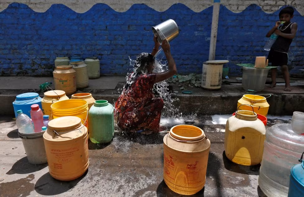 Người phụ nữ dội nước lên người ở vùng ngoại ô Kolkata để “hạ nhiệt” cơ thể.