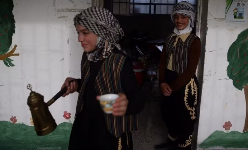 Các bạn nữ sinh phục vụ cà phê trong buổi lễ bế giảng năm học trong một ngôi trường ở Douma, nơi phe nổi dậy Syria nắm quyền kiểm soát.