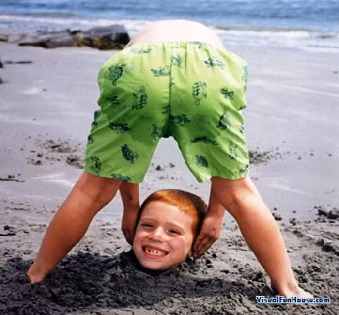 Thực ra, phần thân của bé trai này đang nằm trong cát.