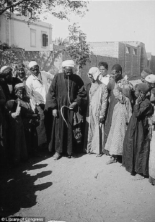 Đám đông vây quanh một người bắt rắn năm 1900.