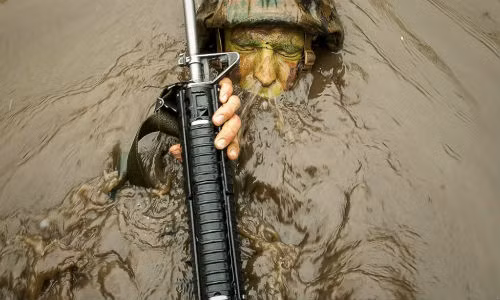 Một thủy quân lục chiến với bài tập bơi ngửa với tư thế tay ôm súng. Đây là bài huấn luyện khó đòi hỏi người lính phải đủ sức khỏe để duy trì động tác trong thời gian dài.