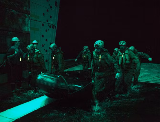  Thủy quân lục chiến Mỹ là lực lượng đổ bộ chính trong các chiến dịch viễn chinh của quân đội Mỹ. Họ được ví là những người tiên phong trong những trận đánh. Do đó quá trình đào tạo có vai trò rất quan trọng. Ảnh: Các binh lính đang chuẩn bị xuồng cao su trong một hoạt động huấn luyện vào ban đêm.