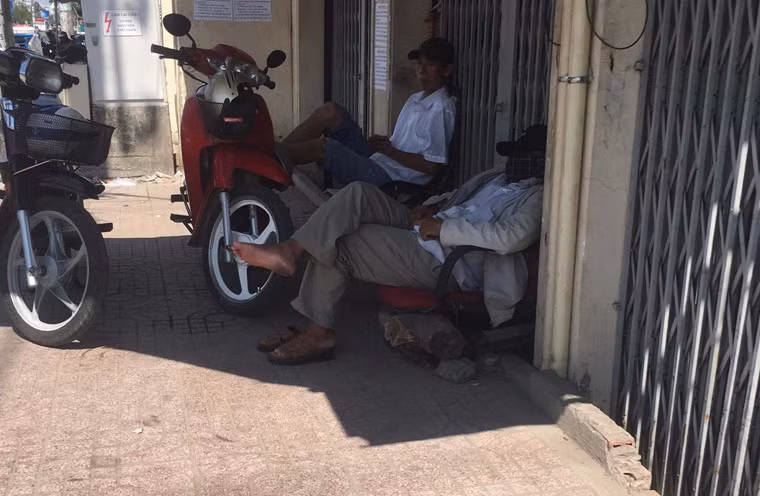 Những người chạy xe ôm trên đường Lũy Bán Bích, quận Tân Phú khốn đốn vì nắng nóng phải tìm bóng mát để trốn nắng.
