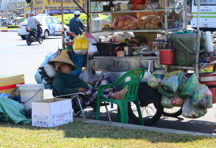 Người phụ nữ mưu sinh trên đường vô cùng mệt mỏi vì nắng nóng.