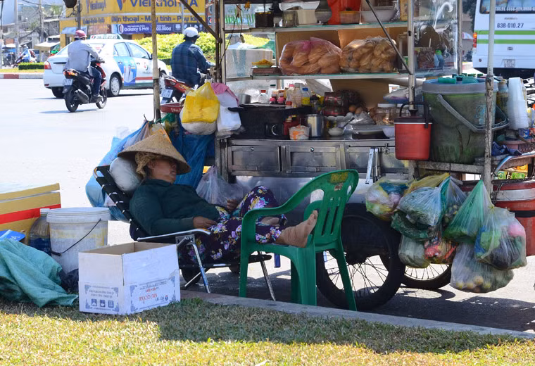 Người phụ nữ mưu sinh trên đường vô cùng mệt mỏi vì nắng nóng.