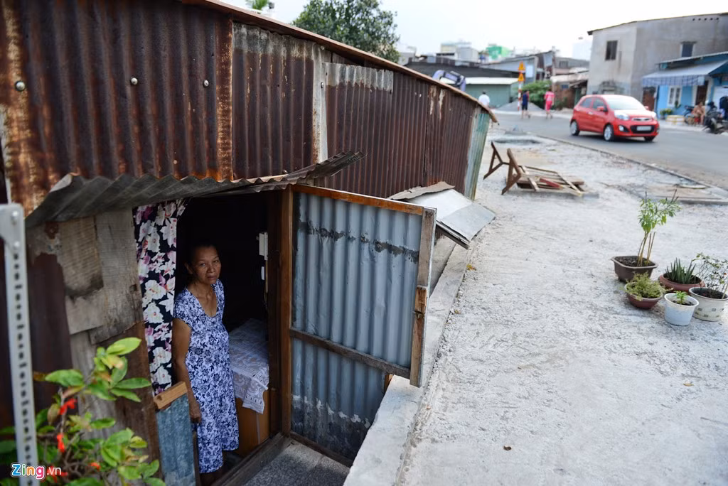 Nhà của bà Phan Kim Sa có mái hiên chạm mặt đường, ngày ngày phải chịu cảnh khói bụi nhưng cái mà bà lo lắng nhất vẫn là vào mùa mưa, nước từ mặt đường tràn vào nhà.