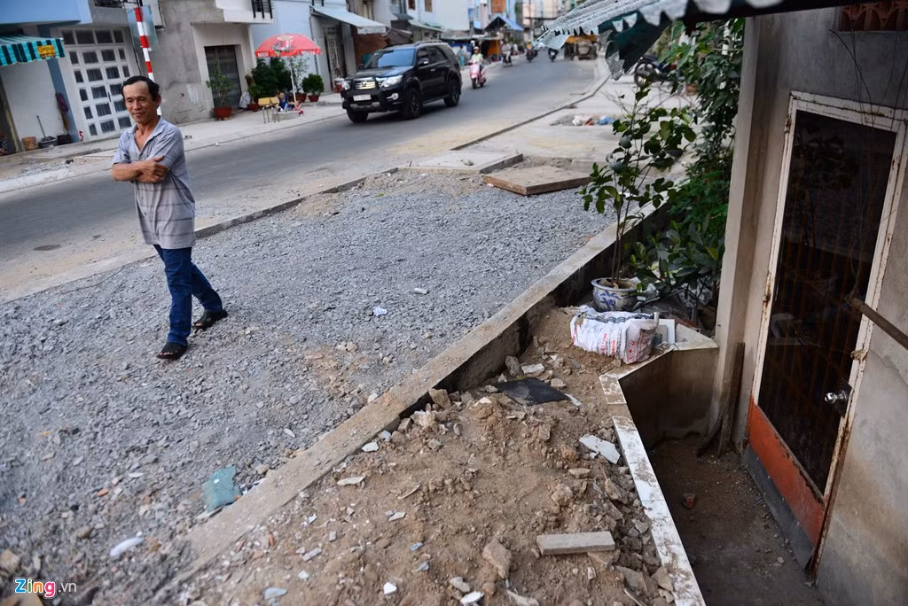 Nhiều đoạn đường vẫn chưa hoàn thiện. Có nhà xây bức vách ngăn lớp đất để có thể mở được cánh cửa ra vào.
