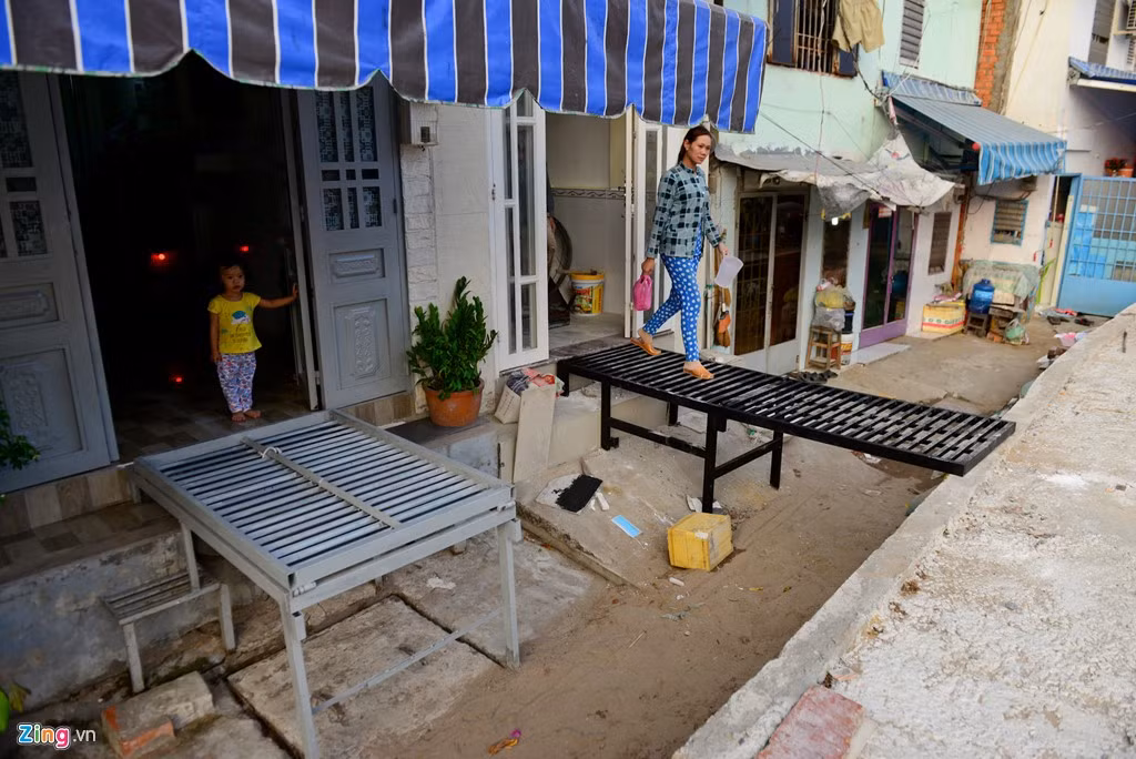 Gia đình nào có điều kiện nâng nhà cao thì bắc cầu tạm ra đường. Ông Lê Ngọc Phúc, một hộ dân tại đây cho biết không thể đổ đất để tiện đi lại được vì lối đi chung còn nhiều nhà chưa nâng. Nếu ông đổ đất lên sẽ bít luôn lối đi của các hộ kế bên, đồng thời nhà nước cũng chưa có quy định cụ thể nên không dám làm.