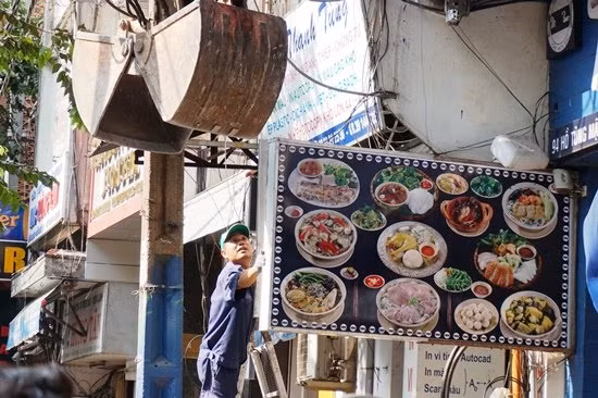 Đoàn kiểm tra sử dụng xe chuyên dụng để xử lý những biển hiệu, mái hiên nằm ở vị trí cao, khó tiếp cận.