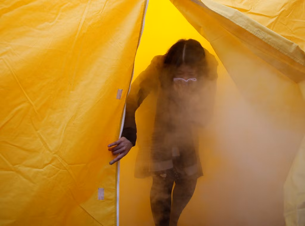 Người phụ nữ tập đi qua lều đầy khói trong cuộc diễn tập hôm 10/3. Từ tháng 11/2016, chính quyền Nhật Bản đã cho phép người dân đăng ký để được phép qua đêm trong thị trấn, nơi cách lò phản ứng hạt nhân bị rò rỉ chỉ 4 km.