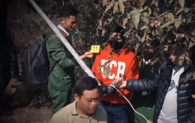 Khi thấy nạn nhân không để ý, Sinh nhặt khúc gỗ ven đường đập mạnh vào gáy Vềnh. (Ảnh: Dựng lại hiện trường. ANTV)