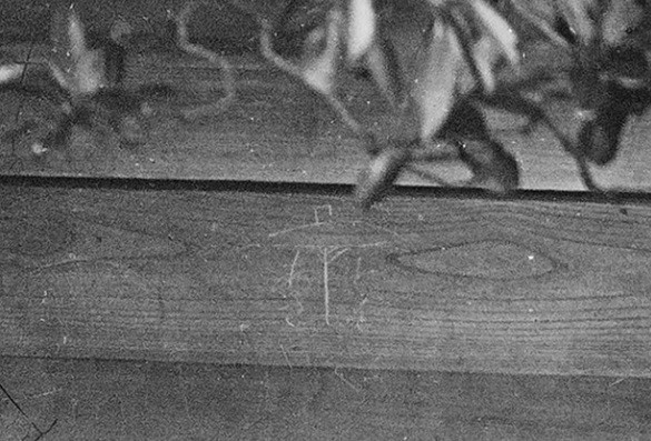 Trên bức tường gỗ của cánh cổng ngôi chùa có một bức vẽ nguệch ngoạc có thể do trẻ con tạo ra.