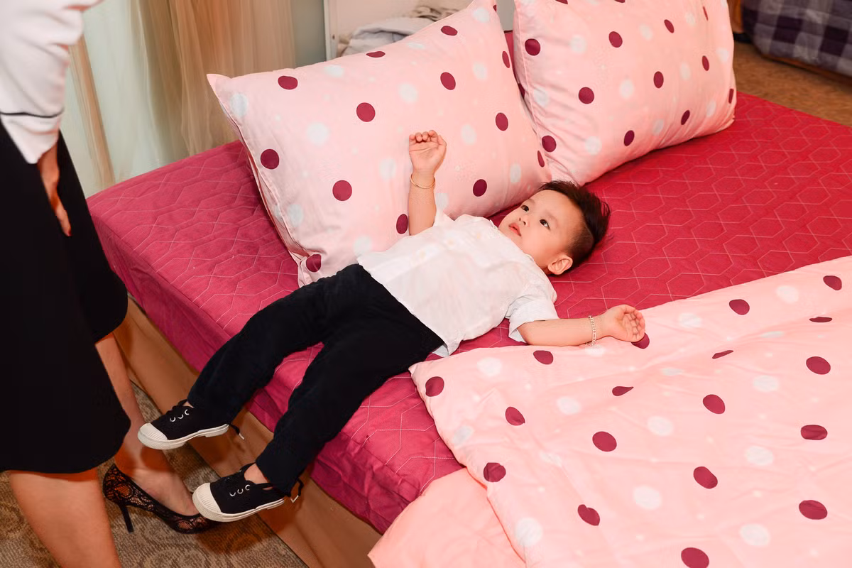 Bé Noah nằm kềnh ra giường khi chơi đùa cùng mẹ.