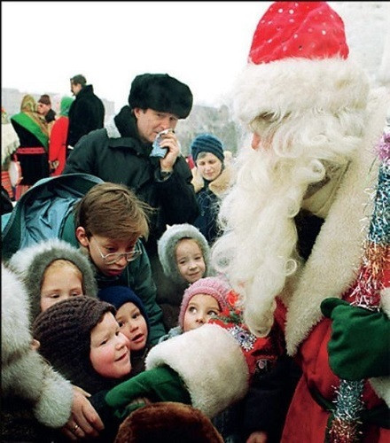 Nhiều trẻ em vây quanh ông già Noel.