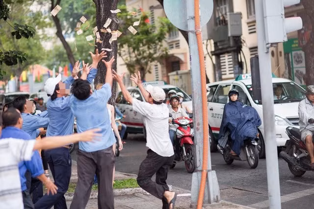 Những hình ảnh ghi lại được trên phố cho thấy cô gái mặc cho nhóm đàn ông nhặt tiền, vẫn bước đi và cười ra vẻ rất mãn nguyện, thích thú.