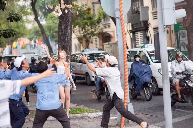 Chiều 7/9, nhiều người qua đường đoạn ngã tư Lê Thánh Tôn giao với Nam Kỳ Khởi Nghĩa, Quận 1, TP HCM không khỏi ngạc nhiên trước cảnh một chân dài 9X ném cả đống tiền để người xung quanh thi nhau nhặt.