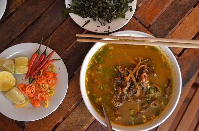 Công thức chế biến đơn giản, song để có một tô cháo lươn ngon đòi hỏi khá nhiều kỹ thuật của người nấu trong việc sơ chế lươn, canh lửa khi hầm và tỷ lệ gia vị khi xào. Đảo nhẹ tô cháo, phần lươn xào sẽ quyện vào, tạo nên sắc vàng bắt mắt. Ngoài cháo lươn, miến lươn cũng là món ăn được lựa chọn nhiều nhất khi đến vùng đất này. Ảnh: Thedropoutdiaries.