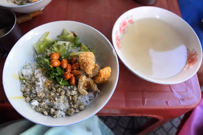 Cơm hến miền Trung có vị chua thanh của khế, thơm ngậy của rau thơm, tươi ngọt của bắp chuối, bạc hà, cay của ớt, đậm đà của mắm ruốc, ngọt dẻo của cơm, đằm thắm của hến, béo ngậy của tóp mỡ... Ảnh: An Huỳnh.