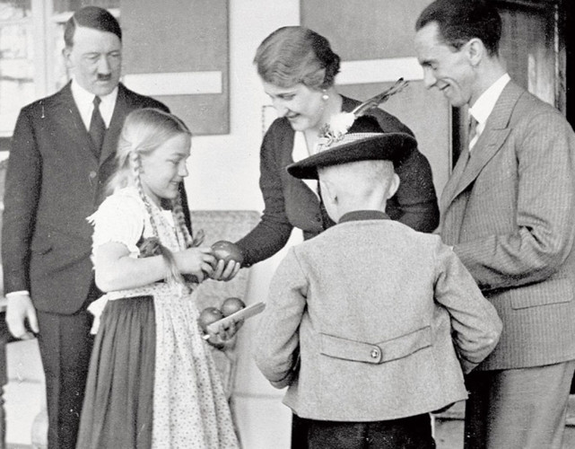Hình ảnh Hitler đứng quan sát vợ chồng Bộ trưởng Tuyên truyền của Đức Quốc xã Magda và Joseph Goebbels tặng quà cho 2 đứa trẻ.