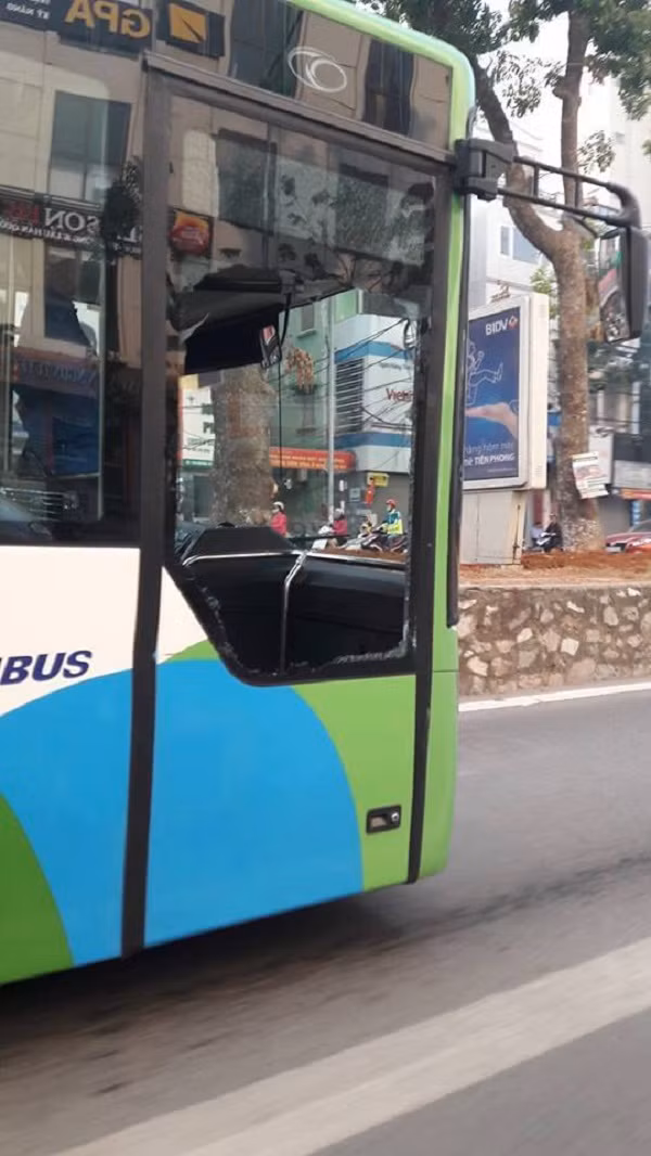 Kính của chiếc xe buýt nhanh BRT bị vỡ tan tành sau khi va chạm.
