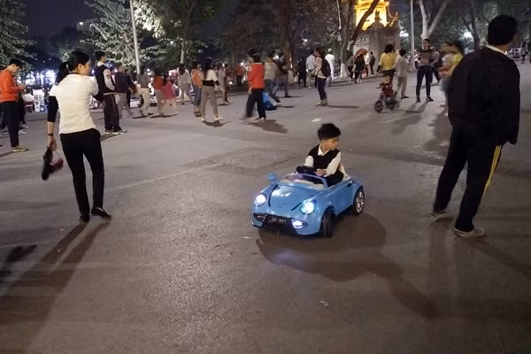 Người đi bộ phải tránh đường cho xe ô tô điện trẻ em trong không gian đi bộ.