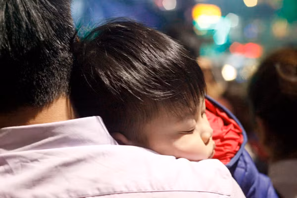 Em nhỏ ngủ gục một cách đáng yêu ngay trên vai bố giữa khoảnh khắc giao thừa.