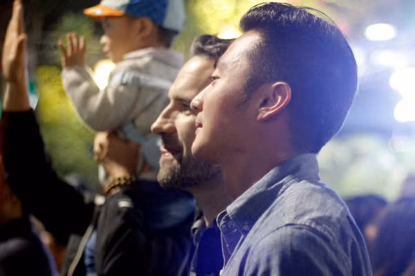 Nam thanh niên người Việt Nam cùng anh bạn người nước ngoài cùng nhau đón khoảnh khắc giao thừa.