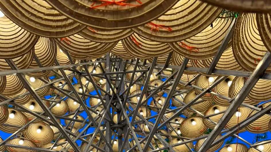 Khung sườn của cây thông Noel được tạo thành từ việc gắn kết của khung sắt, nên rất chắc chắn. Mỗi chiếc nón đều có bóng đèn bên trong và đèn nháy trang trí xung quanh mang không khí giáng sinh ở nhà thờ Bến Bàu thêm rực rỡ. Ảnh: Gia Minh