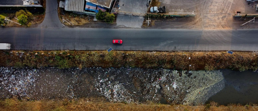 Những chiếc ô tô di chuyển gần kênh Interceptor Poniente ở Cuautitlan, Bang Mexico, Mexico, ngày 18/3/2021. Hệ thống thoát nước xung quanh Thành phố Mexico đông dân, trong đó bao gồm kênh Interceptor Poniente, bị ô nhiễm nặng do nước thải và rác thải từ khu dân cư gần đó.