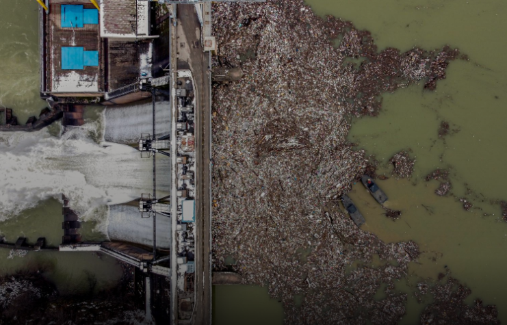 Các công nhân đang thu gom rác nhựa thải ra hồ Potpecko bị ô nhiễm gần nhà máy thủy điện của một con đập gần thị trấn Priboj, Serbia, ngày 29/1/2021.