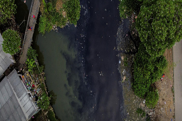 Dòng sông Pisang Batu, chảy qua một khu dân cư đông đúc ở Bekasi, ngoại ô Jakarta, Indonesia, ngày 16/3/2021. Con sông này cũng bị ô nhiễm nặng, nước đen và bốc mùi.