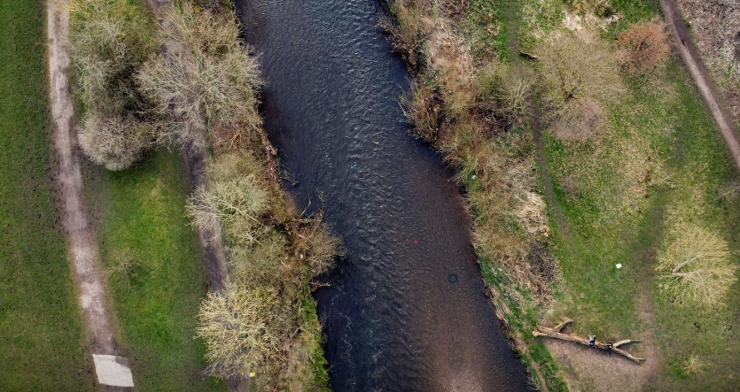 Một vài người đi bộ dọc theo bờ sông Tame gần Denton, Anh, ngày 17/3/2021. Một báo cáo của Đại học Manchester vào năm 2018 chỉ ra rằng sông Tame có mức độ ô nhiễm vi nhựa "tồi tệ hơn so với bất cứ nơi nào khác trên thế giới vào thời điểm đó".