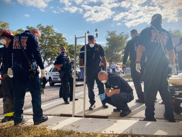 Nhiều người dân tập trung tại hiện trường đã vỗ tay khi người phụ nữ được đưa từ cống lên mặt đất an toàn.