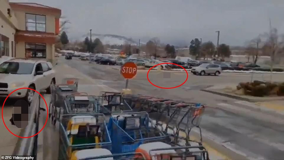 Một đoạn video về vụ xả súng kinh hoàng được đăng tải trên mạng cho thấy 2 nạn nhân (khoanh đỏ) nằm trên mặt đất tại bãi đỗ xe của siêu thị.