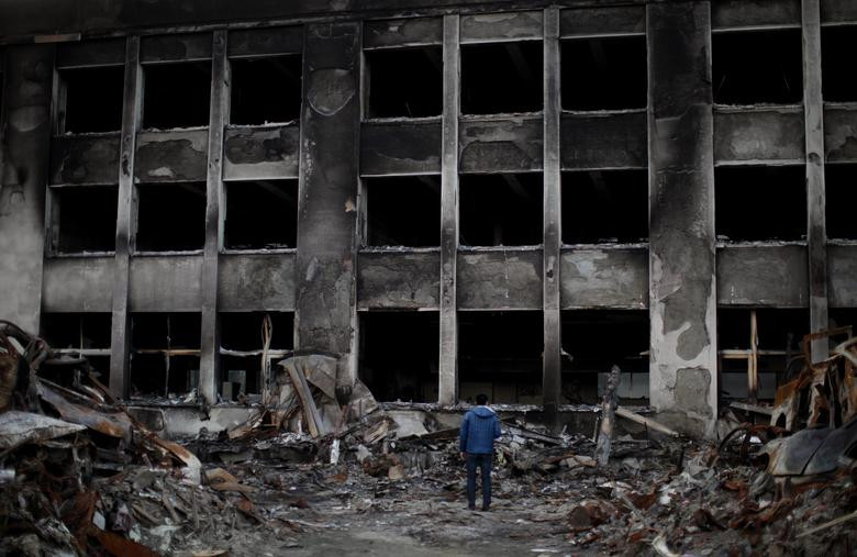 Người đàn ông đứng trước Trường tiểu học Kadonowaki ở Ishinomaki ngày 7/4/2011. Ngôi trường đã bị thiêu rụi trong thảm họa động đất - sóng thần năm đó.