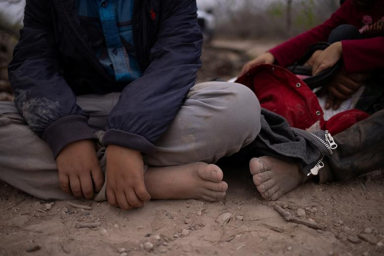 Damaris và con trai Jonathan, 10 tuổi, đi chân trần sau khi vượt sông Rio Grande từ Mexico vào Mỹ ngày 14/3.