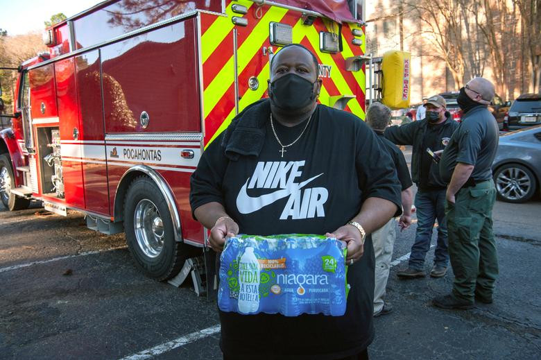 Tình nguyện viên Brad Davis phân phát nước tại một khu chung cư ở Jackson, ngày 4/3.