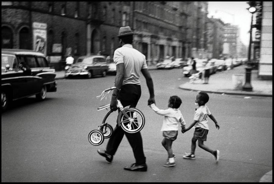 Người đàn ông dắt hai em nhỏ qua đường ở Harlem, New York, năm 1963.