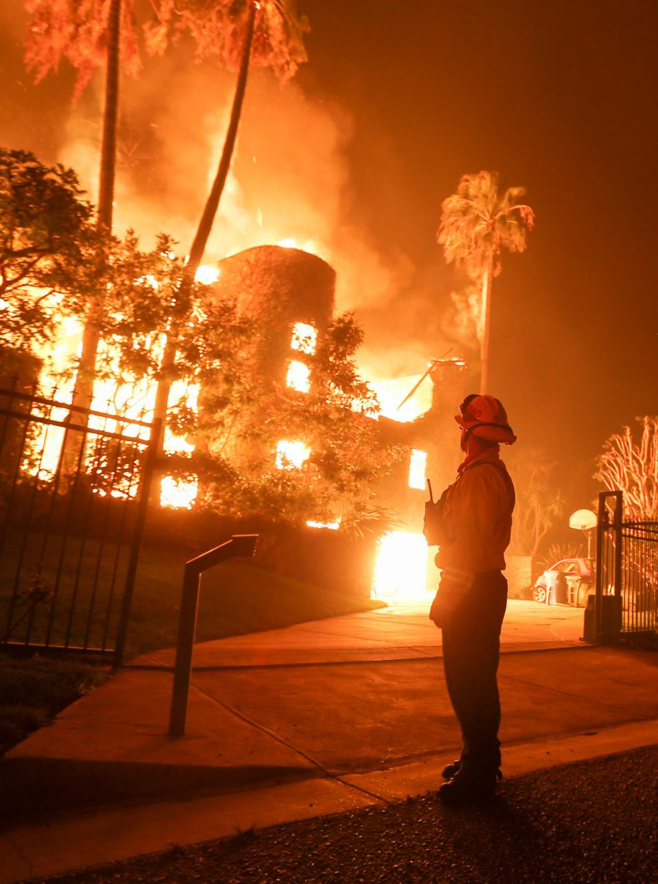 Lính cứu hỏa đứng nhìn một ngôi nhà bị thiêu rụi trong đám cháy Woolsey ở Malibu.