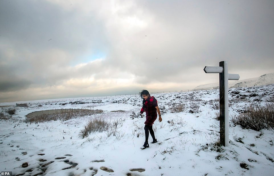 Một phụ nữ đi qua vùng đất phủ đầy tuyết trắng ở Derbyshire.