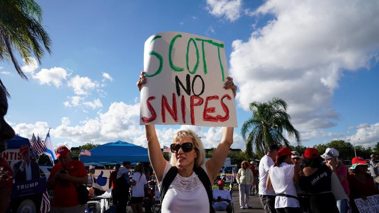 Người phụ nữ mang theo khẩu hiệu đứng bên ngoài văn phòng bầu cử quận Broward trong buổi kiểm phiếu lại tại Lauderhill. Dự kiến, kết quả cuộc kiểm phiếu lại tại Florida sẽ có vào lúc 15 giờ chiều 15/11 (giờ địa phương).