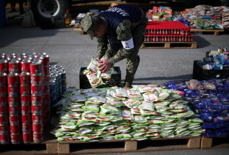 Binh sĩ Mexico hỗ trợ việc chuẩn bị đồ ăn bên ngoài khu trú ẩn tạm thời cho người nhập cư ở Tijuana ngày 21/11.
