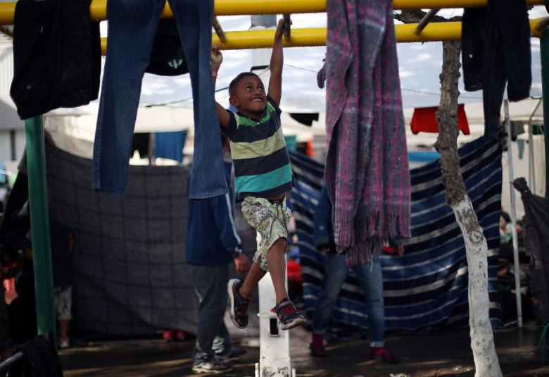 Một bé trai chơi đùa trong khu lán trại ở Tijuana ngày 22/11.