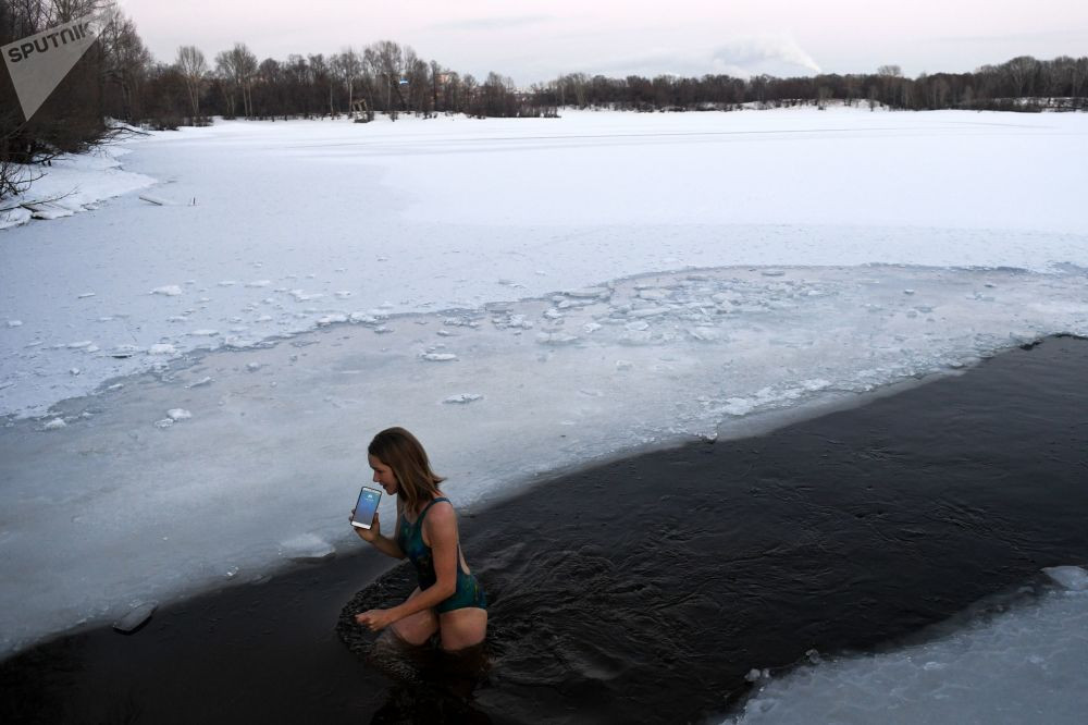 Một cô gái thuộc câu lạc bộ bơi mùa đông tắm ở một hố băng trong hồ nước ở Lenisky, tỉnh Novosibirsk.
