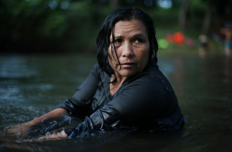 Bà Anna-Maria Sadillon, 55 tuổi, tắm dưới suối trong lúc dừng chân tại Tapanatepec, Mexico, ngày 28/10, trước khi tiếp tục chặng hành trình dài phía trước. Mời độc giả xem thêm video: Hành trình gian khổ của người tị nạn Syria trên đất Châu Âu (Nguồn: VTC14)